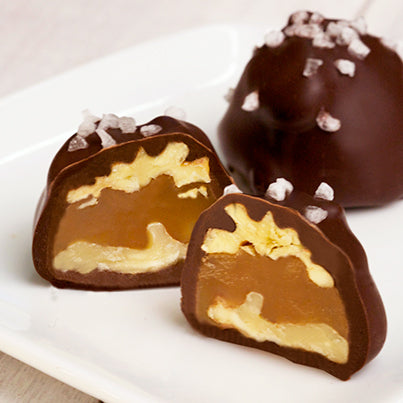 A walnut caramel cluster cut in half to reveal the walnuts and caramel inside.